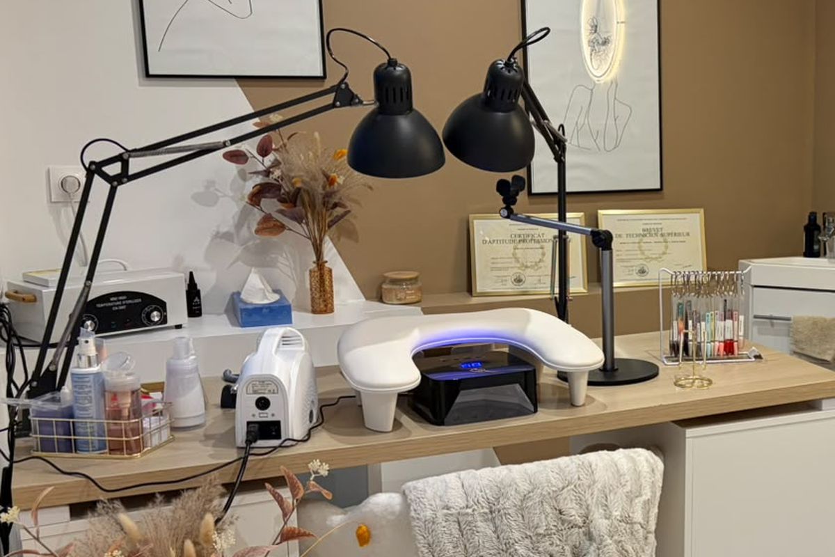 Le poste de manucure : lampe LED, ponceuse, présentoir de vernis et diplômes encadrés